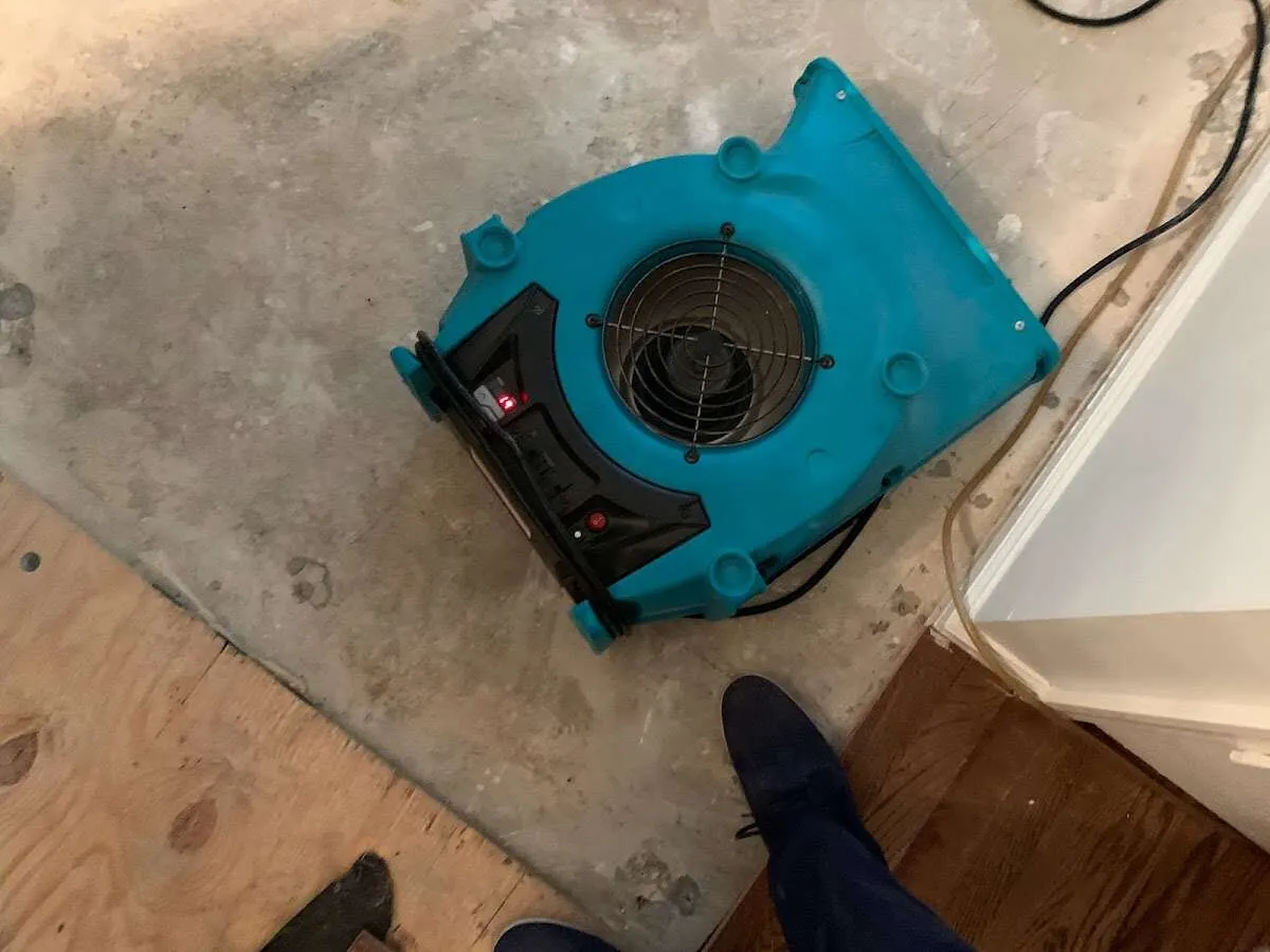 Air mover drying subfloor during Leak Detection & Repair in Cornwall